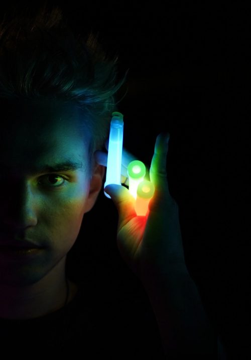 Person holding glowing multicolored lights in the dark